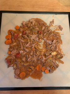Spreading stew on dehydrator tray.